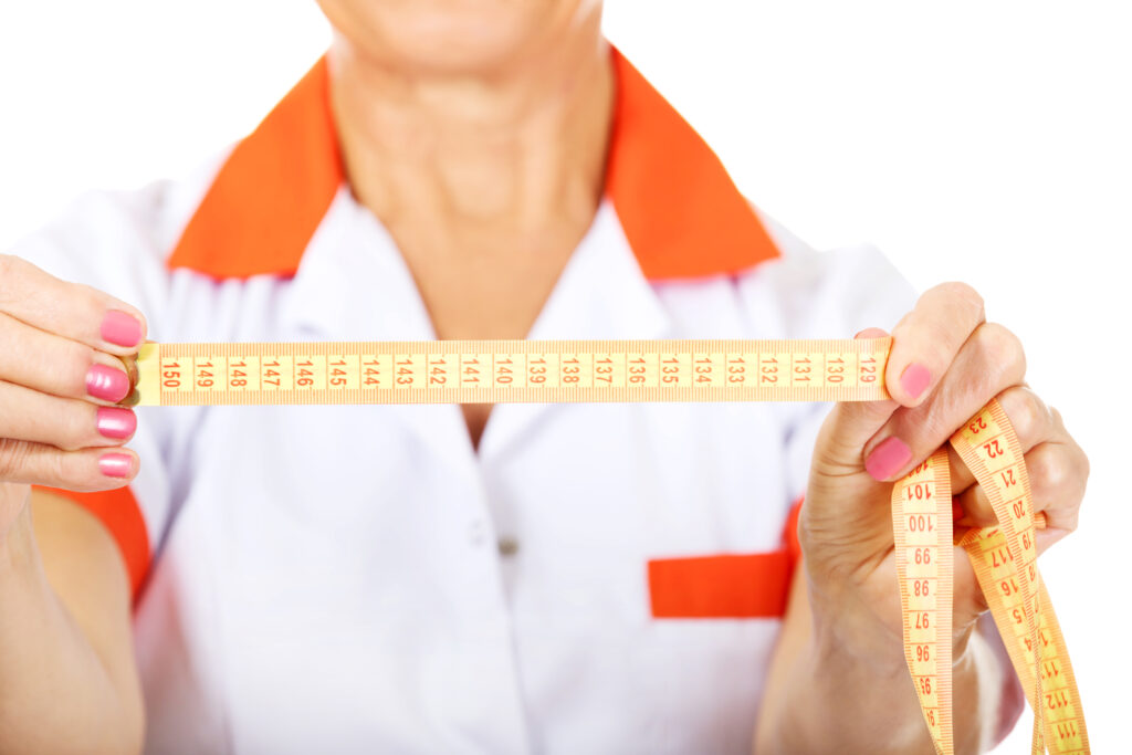 Traveling to Mexico for weight loss surgery - nurse showing measuring tape results in Tijuana